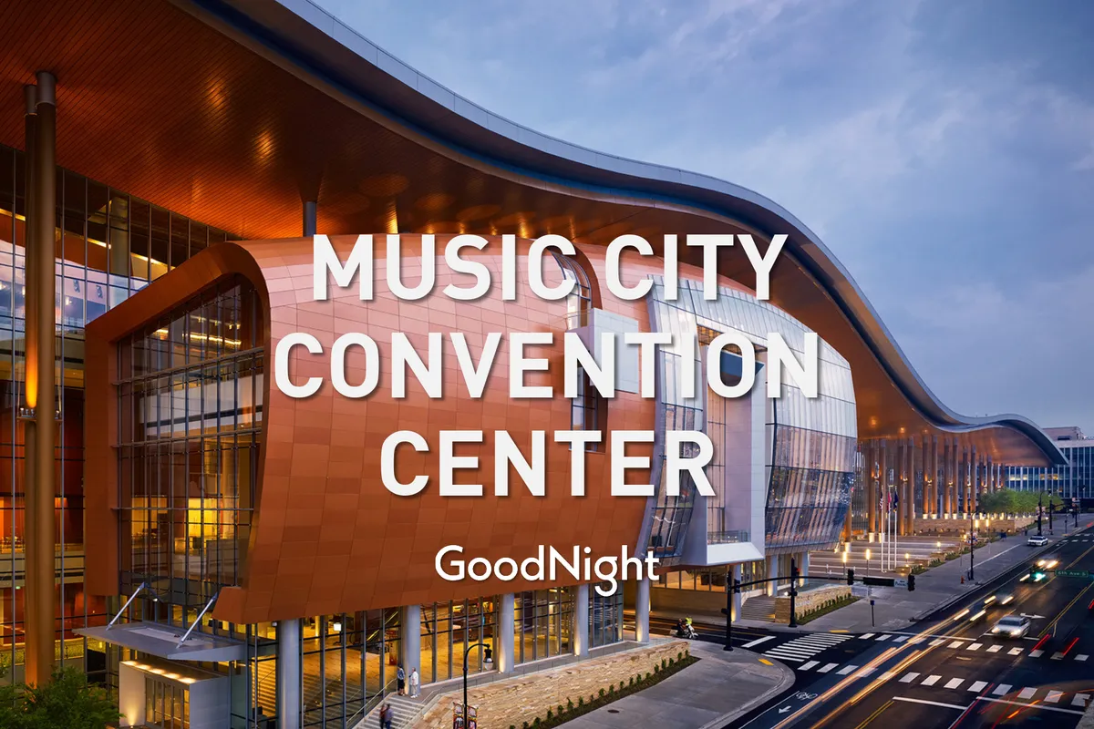 A striking exterior shot of the Music City Center, Nashville’s iconic convention hub. The modern, curved glass architecture is framed by busy urban streets, capturing a sense of energy and accessibility. The perspective highlights the building's significance as a major event and business venue in the city.
